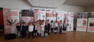 Grupa dzieci na tle plansz z historią Polski 