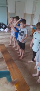 Pięcioro dzieci stoi naprzeciwko ławki gimnastycznej