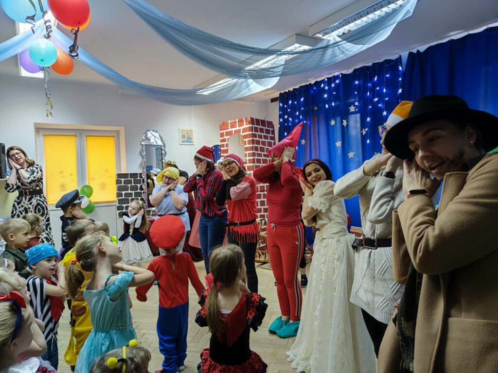 Dzieci na balu karnawałowym podczas zabawy tanecznej.