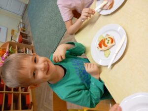 Chłopiec prezentuje zdrową kanapeczkę przez siebie wykonaną z wykorzystaniem zdrowych produktów