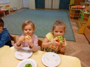 Dwie dziewczynki z apetytem zjadają zdrowe kanapki przez siebie wykonane
