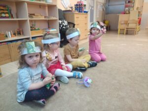 Dzieci z opaskami przedstawiającymi słowika grają na janczarach