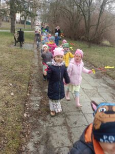 Grupa dzieci z "gaikami" w ręku podczas spaceru po parku