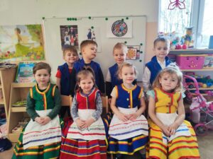 Cztery dziewczynki i czworo chłopców w kolorowych warmińskich strojach.