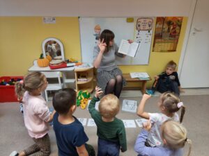 nauczycielka prezentująca ćwiczenie dzieciom, dzieci wykonują gest palcami