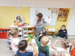 nauczycielka prezentująca ćwiczenie dzieciom, dzieci wykonują gest palcami