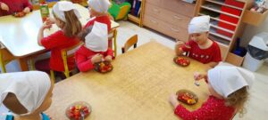 Grupa dzieci próbująca sałatki pomidorowej.