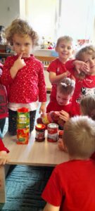 Grupa dzieci przyglądająca się pomidorom przetworzonym.