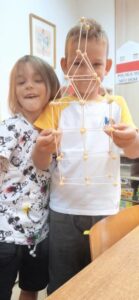 Dwóch chłopców trzyma konstrukcję przestrzenną z wykałaczek.