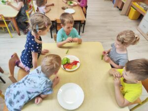 Grupa dzieci degustująca pokrojone warzywa.