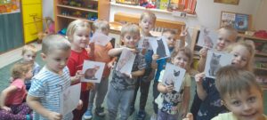 Kilkoro dzieci trzyma ilustracje przedstawiające zwierzęta domowe.