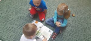 Dzieci oglądające książkę o zwierzętach domowych.
