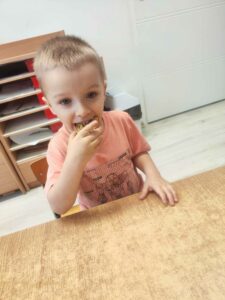 Chłopiec jedzący świeżo upieczony chleb dyniowy.