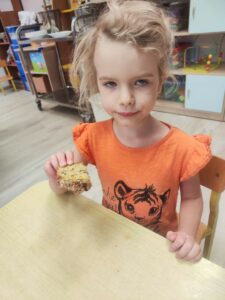 Dziewczynka trzymająca chleb w ręce.