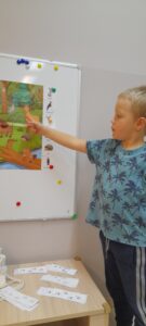 Chłopiec wskazuje na planszy zwierzę leśne.