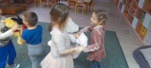 Dzieci tańczące w parach razem z pluszowymi misiami.