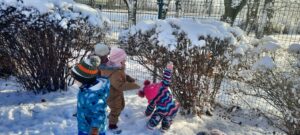 Czworo dzieci bawi się na śniegu 