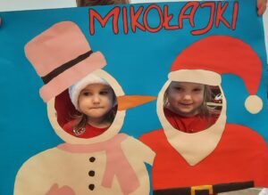 Dwoje dzieci w fotobudce z napisem "Mikołajki" 