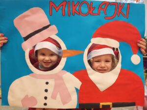 Dwoje dzieci w fotobudce z napisem "Mikołajki" 