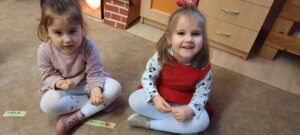 Dwie dziewczynki siedzą na dywanie 