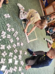 Dwóch chłopców układa drogę dla ozobota z puzzli.