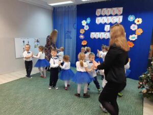 Grupa dzieci tańcząca tango podczas występu z okazji Dnia Babci i Dziadka.