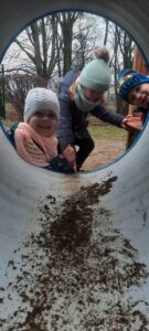 Troje dzieci bawi się w tunelu przedszkolnym 