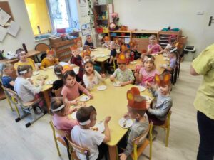 dzieci siedzą przy stoliku i zajadają przepyszny tort urodzinowy Misia Uszatka
