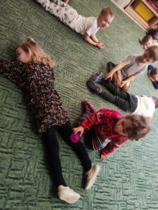 Dzieci wykonujący masaż piłeczkami sensorycznymi.
