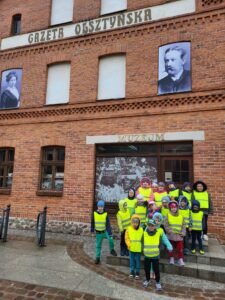 grupa dzieci stoi przed Muzeum Gazety Olsztyńskiej
