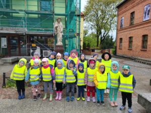 grupa dzieci stoi przed pomnikiem św. Jakuba