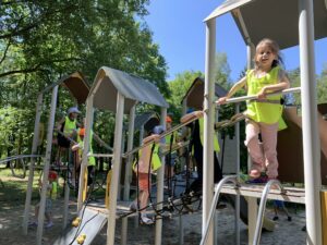 grupa dzieci na sprzęcie terenowym na placu zabaw