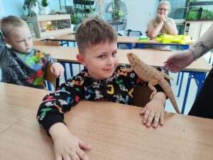 Chłopiec trzymający iguanę na ramieniu