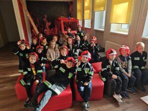 Dzieci w strojach strażackich na sali edukacyjnej "Ognik"