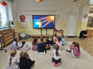 Grupa dzieci oglądająca film edukacyjny na temat wędrówki wody w przyrodzie