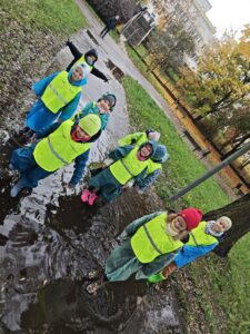 Przedszkolaki w parku Kusocińskiego podczas zabawy w kałuży