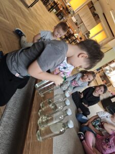 Chłopiec odmierzający wodę w butelkach