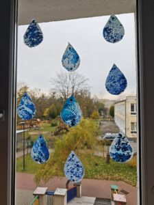 Praca plastyczna dzieci w formie kropel deszczu na oknie przedszkolnym