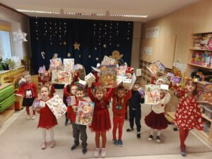 Grupa dzieci w sali przedszkolnej.