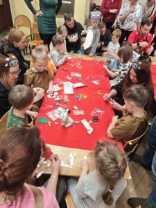 Dzieci wraz z rodzicami podczas warsztatów świątecznych