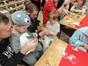 Dzieci wraz z rodzicami podczas warsztatów świątecznych